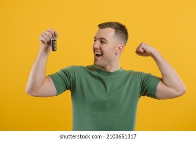 Shocked Young Man Posing Isolated On Yellow Orange Background, Studio Portrait. People Emotions Lifestyle Concept. Mock Up Copy Space. Holding In Hand Car Keys, Showing Thumb Up