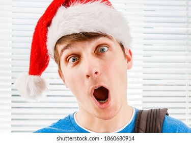 Shocked Young Man in Santa Hat on the Jalousie Background closeup - Powered by Shutterstock