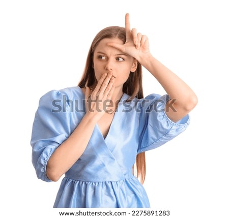 Shocked young woman in dress showing loser gesture on white background