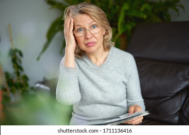 Shocked,woman reading newspaper bad news