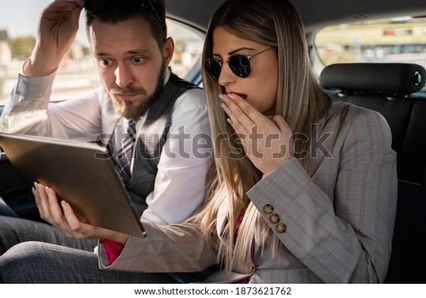Shocking, bad news , woman and man business\
people reading shocking news on tablet\
