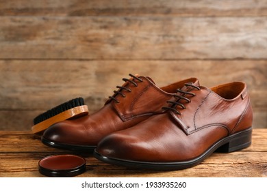 Shoe care products and footwear on wooden table