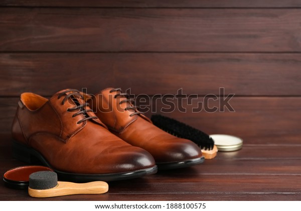 Shoe care products and footwear on wooden table.\
Space for text