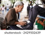 Shoe cleaner, elderly man person and shining feet, small business owner and professional on busy street. Mature, senior male and experienced worker from Puerto Rico, working with brush in city