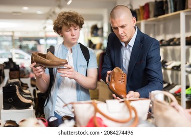 Shoe Store Employee Helping Teen To Choose Classic Brown Shoes In A Shoe Store