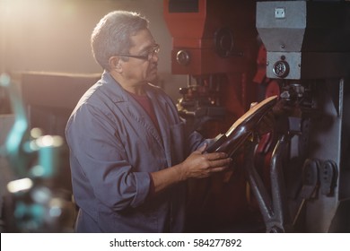 Shoemaker examining a shoe in workshop - Powered by Shutterstock