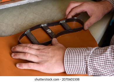 Shoemaker Hands Putting Steel Form On Leather To Make Shoe Insole On Cutting Machine In Workshop. Leather Crafting Handmade Shoes. Selective Focus