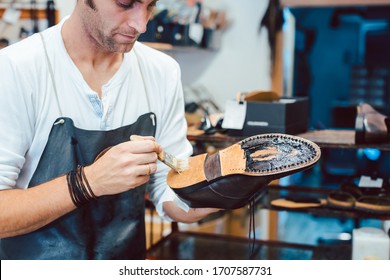 Shoemaker Putting Glue On Sole Of A Shoe To Fix