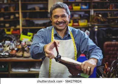 Shoemaker repairing a shoe in workshop - Powered by Shutterstock