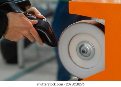 Shoemaker, shoes master using automatic shoe polish machine tool for polishing black leather women footwear at workshop - close up - Powered by Shutterstock