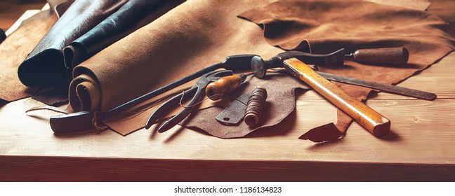 Shoemaker's Work Desk. Tools And Leather At Cobbler Workplace. Set Of Leather Craft Tools On Wooden Background. Shoes Maker Tools On Wooden Table