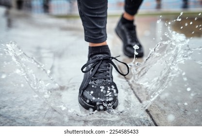 Shoes of person running in the rain, feet splash water in puddle and outdoor cardio in Seattle road. Runner training for marathon, step on wet ground and legs moving fast for fitness exercise - Powered by Shutterstock