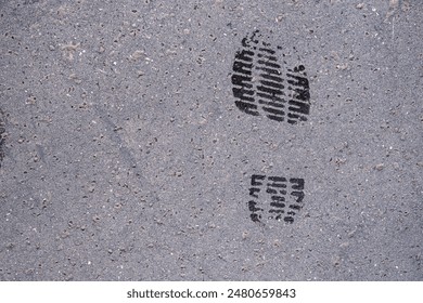 Shoes print on asphalt ground. Sneakers step black mark. Shoe prints on the wall. Human footprints. Footwear steps. Textured dirty wet sole. Minimalist concept. Top view. Close up. Copy space - Powered by Shutterstock