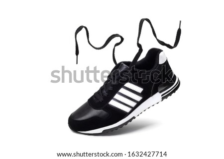 Shoes for the sport. Flying men's black running Shoe with fluttering laces isolated on a white background.