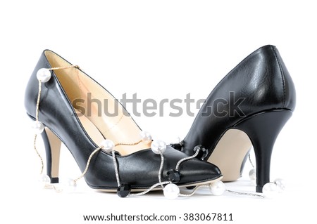 Shoes for women with high heel of black color adorned with string of pearls and photographed on white background.