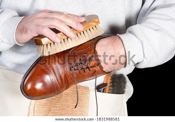 A shoeshine\
man polishing a leather dress\
shoe