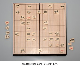 Shogi  a sort of  Japanese chess or the Game of Generals. A two-player strategy board game. One of the classic debutes. Hieroglyphs are the names of chess pieces: i.e. 王將 - king; 飛車 - rook; 歩兵 - pawn