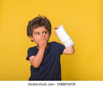 Shoked surprised boy with arm in sling isolated on yellow. Oh no, what I did. Stressful little kid cover open mouth with hand. wants to have active summer holidays. Upset offended kid going to cry - Powered by Shutterstock