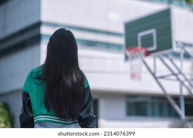 Shoot of backside of girl on basketball court  in university. 
