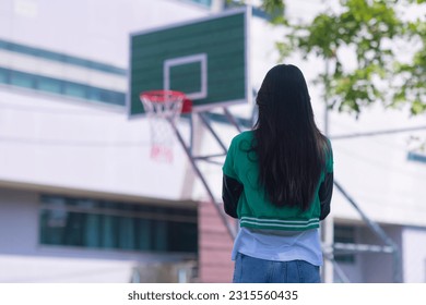 Shoot of backside of girl on basketball court  in university. 
