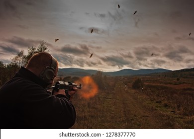 The Shooter Shoots From The Assault Rifle On The Shooting Range. Chases Fly From The Gun And The Flame Whistles From The Barrel. The Situation Is Backlit.