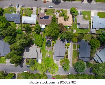 Shooting From A Drone. Small Green Town With Developed Infrastructure. Paved Roads And Footpaths, Roofs Of Small Houses. Cars. Beautiful Nature, Calm Scenes. There Are No People In The Photo.