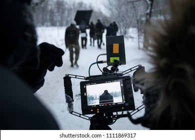 Shooting a feature film, backstage on the set in the street in the winter, the view from the camera. The work of the cameraman