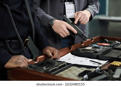 Shooting instructor explaining usage of firearms and safety procedures, demonstrating techniques with various setup on a desk, focusing on hand positions and equipment handling