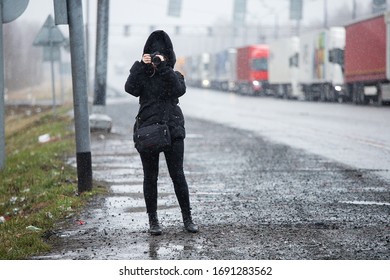 shooting a long queue of trucks at border, a photographer in a medical mask and hood is reporting on the place of quarantine and restricted import, inspection of goods, a traffic jam of many trucks