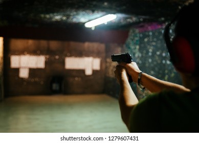 Shooting A Pistol At Target In Indoor Firing Range Or Shooting Range