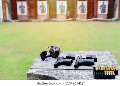 Shooting range.
Gun, bullets, ear plugs and shooting accessories on the table at shooting range.