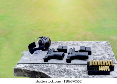 Shooting Range.
Gun, Bullets, Ear Plugs And Shooting Accessories On The Table At Shooting Range.