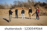 Shooting range instructor demonstrate gun shoot techniques to group of his students. Civilian team weapons training