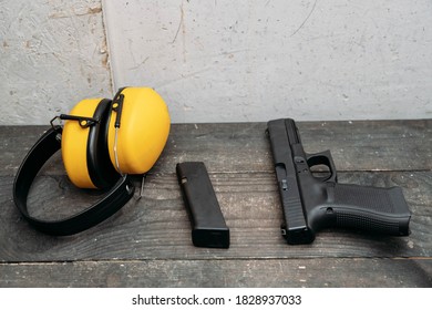 Shooting Range. Protective Earmuffs And A Gun Lie On The Table