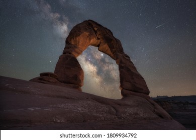 Shooting star and the Milky Way Galaxy behind Delicate Arch lit up - Powered by Shutterstock