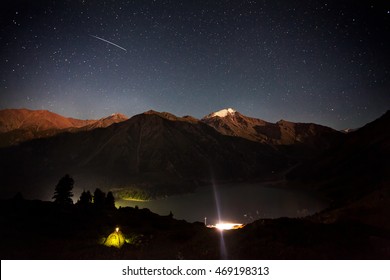 Shooting star at night sky in the mountain camp near Big Almaty Lake in Kazakhstan