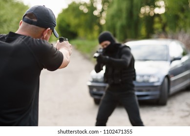 Shootout Between A Police Officer And A Offender. Stop Terrorism And Crime. The Police Officer And The Terrorist Are Aiming Each Other.