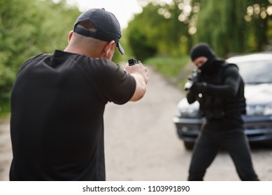 Shootout Between A Police Officer And A Offender. Stop Terrorism And Crime. The Police Officer And The Terrorist Are Aiming Each Other.