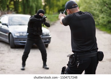 Shootout Between A Police Officer And A Offender. Stop Terrorism And Crime. The Police Officer And The Terrorist Are Aiming Each Other.