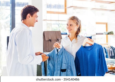 Shop Assistant Helping To Choose Clothes In A Store