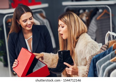 Shop Assistant Helping Customer In Boutique