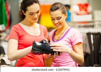 Shop Assistant Helping Customer Choosing Sports Shoes