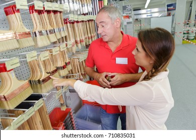 Shop Assistant Helping Customer At Paint Store