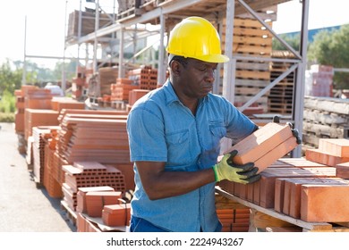 Shop Assistant Man Is Checking Quality Of Bricks In The Open Area Of A Construction Store