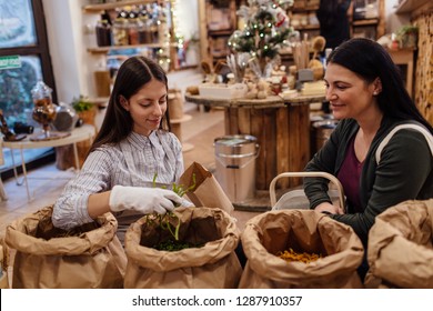 Shop Assistant Serving Customer In Packaging Free Shop. Zero Waste Shopping - Woman Buying Fresh Food At Package Free Grocery Store.