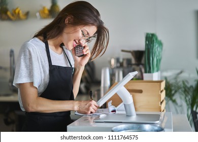 shop assistant taking order on phone in restaurant