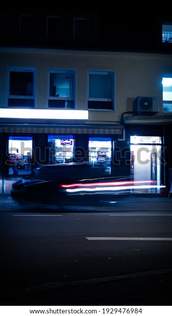 shop with blurred car in\
the night
