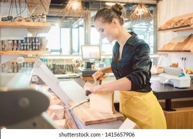 Shop Clerk Woman In Deli Cutting Cheese