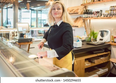 Shop Clerk Woman In Deli Cutting Cheese