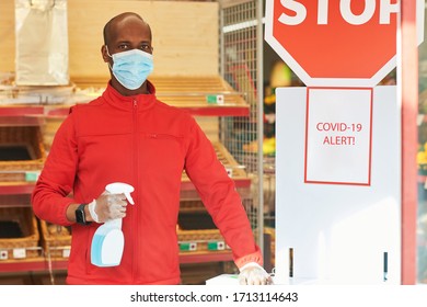 Shop employee at the entrance of the supermarket spraying disinfectant on customers hands for safety measures during covid-19 - Shutterstock ID 1713114643